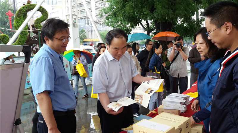 西安市档案局副局长吴立民（左二）、未央区副区长李亚省（左一）翻看宣传册.jpg